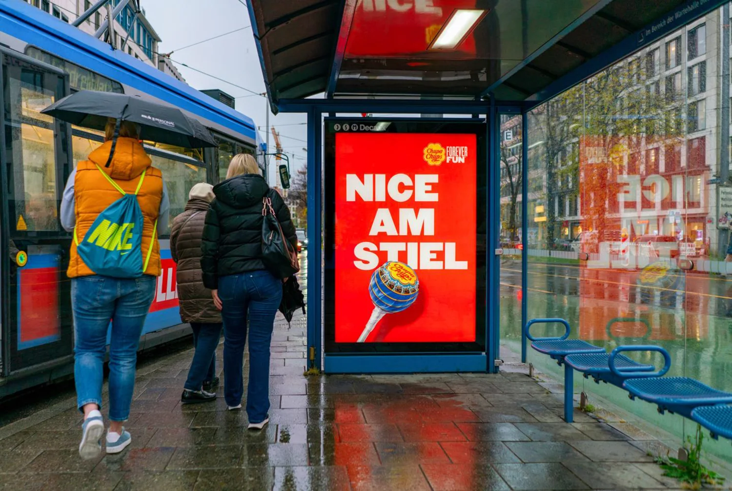 City Light Poster in Buswartehalle in München zeigt Süßwaren-Werbung.
