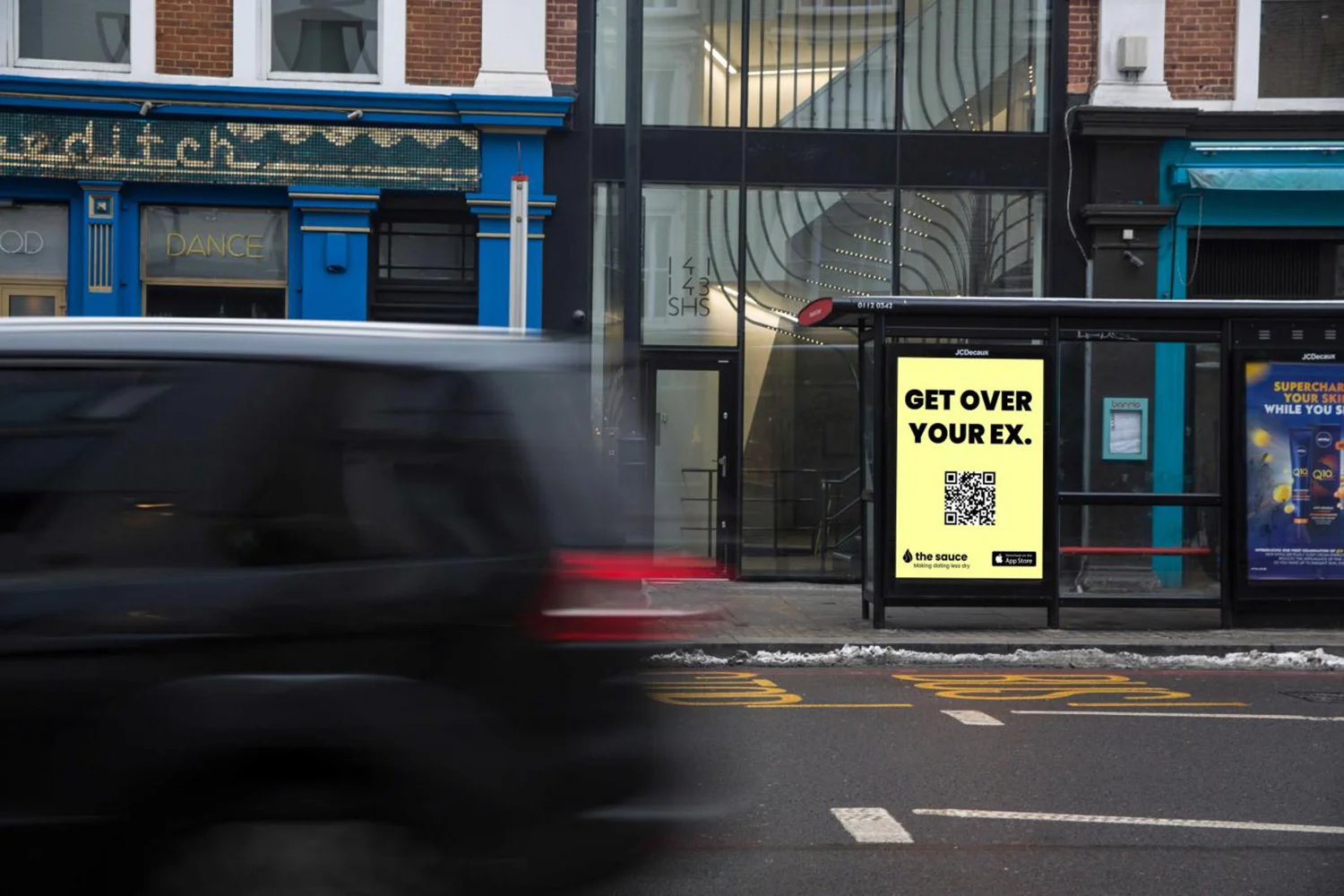 City Light Poster an einer Wartehalle in UK zeigt Werbung für Dating App.