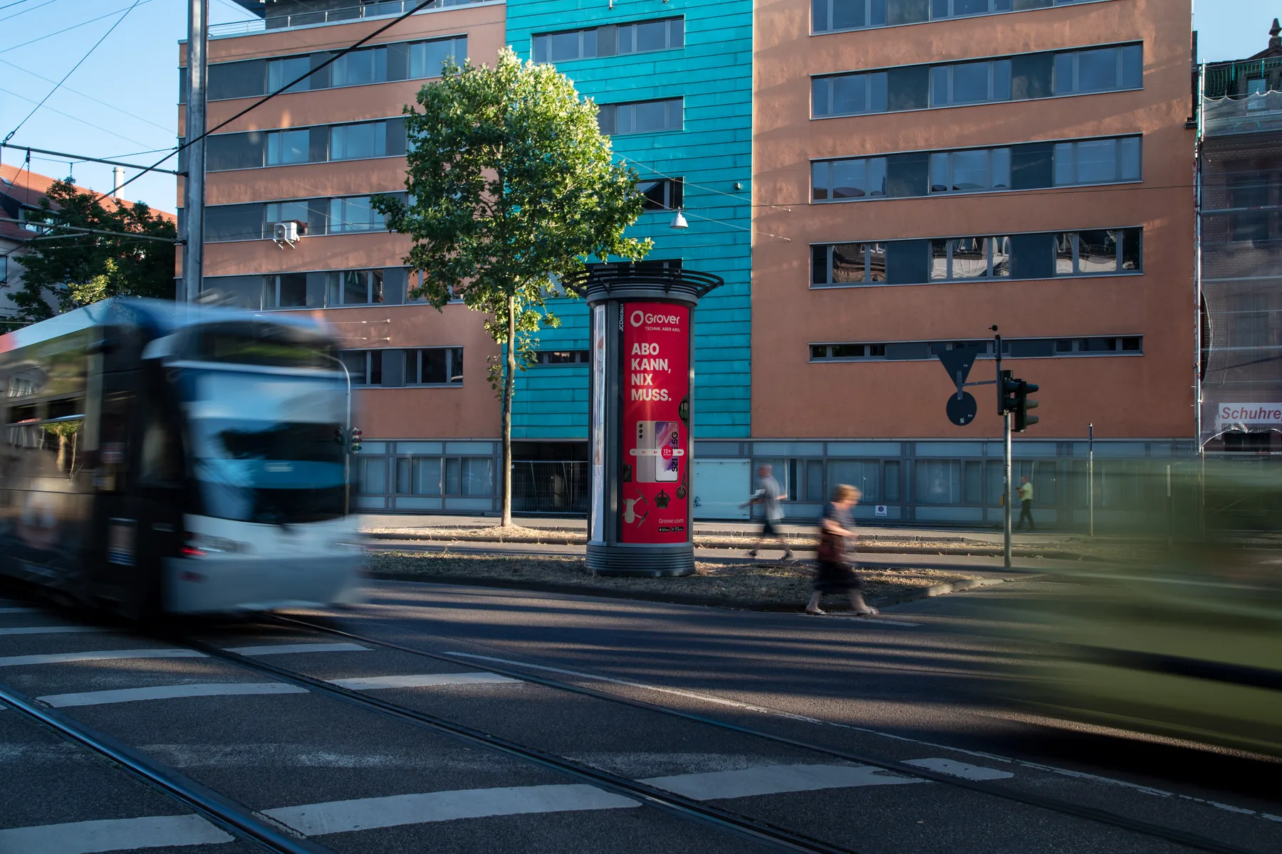 City Light Säule mit Out of Home-Werbung eines Smartdevice-Anbieters an einer Hauptverkehrsstraße in Saarbrücken.