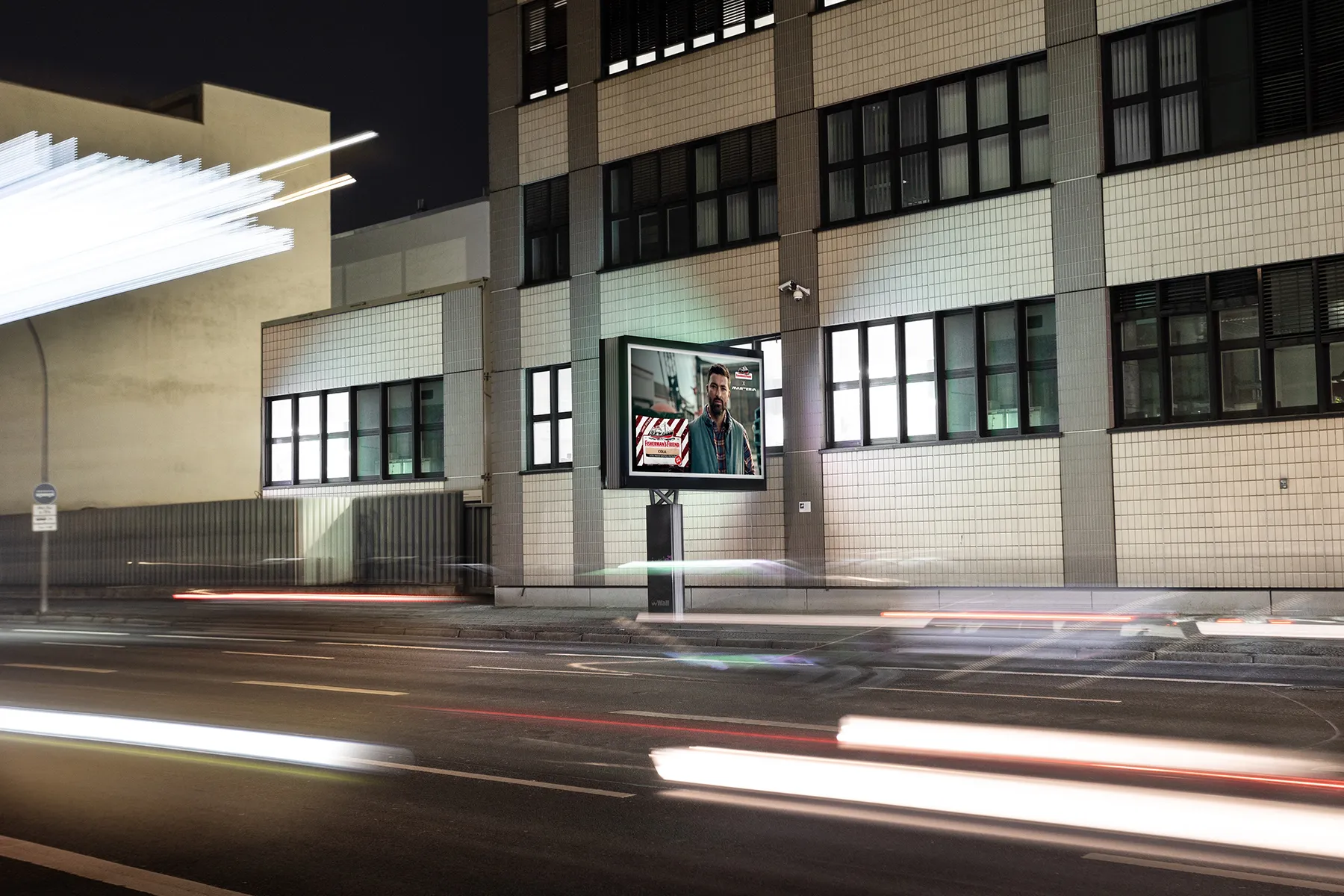 Digital City Light Board zeigt Werbung für Halspastillen in Berlin bei Nacht.