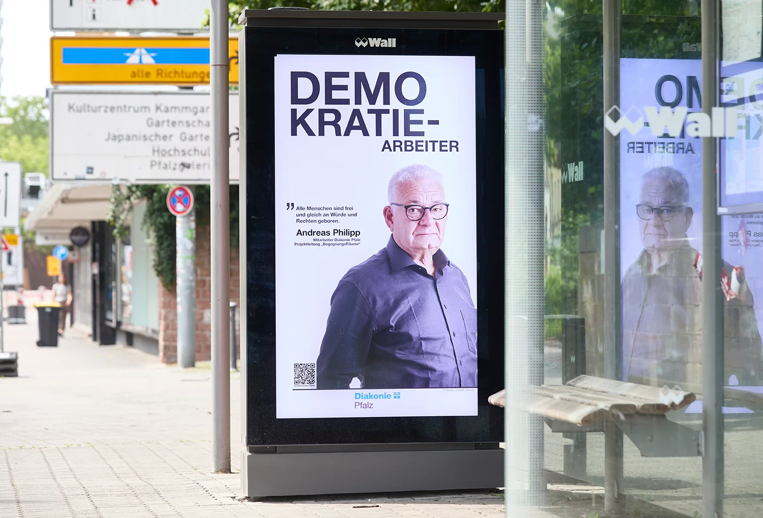 Digital City Light Poster mit Kampagne zur Demokratie an Bus Wartehalle in Kaiserslautern.
