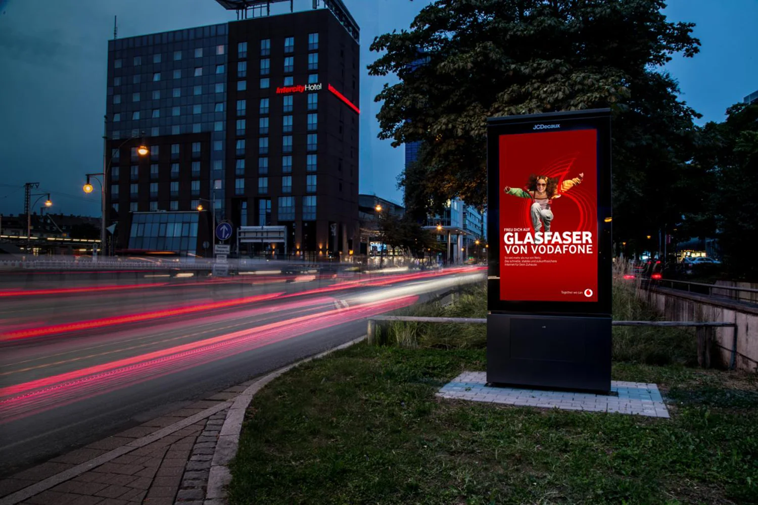 Digital City Light Poster mit Werbung für Glasfaser-Internet an der Bismarckallee in Freibeurg bei Nacht