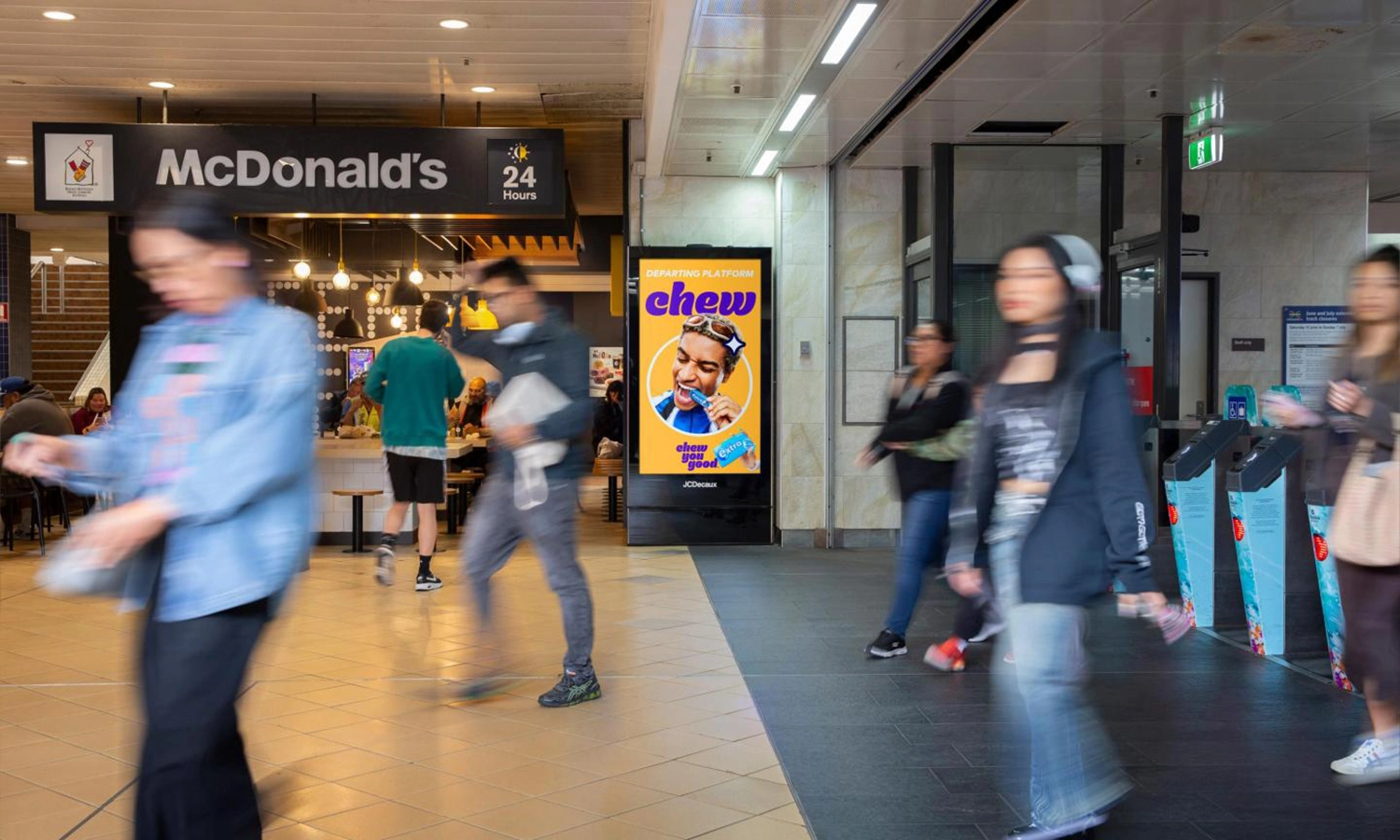 Digital City Light Poster mit Kaugummiwerbung neben einem belebten Ausgang der Brisbane Central Station.