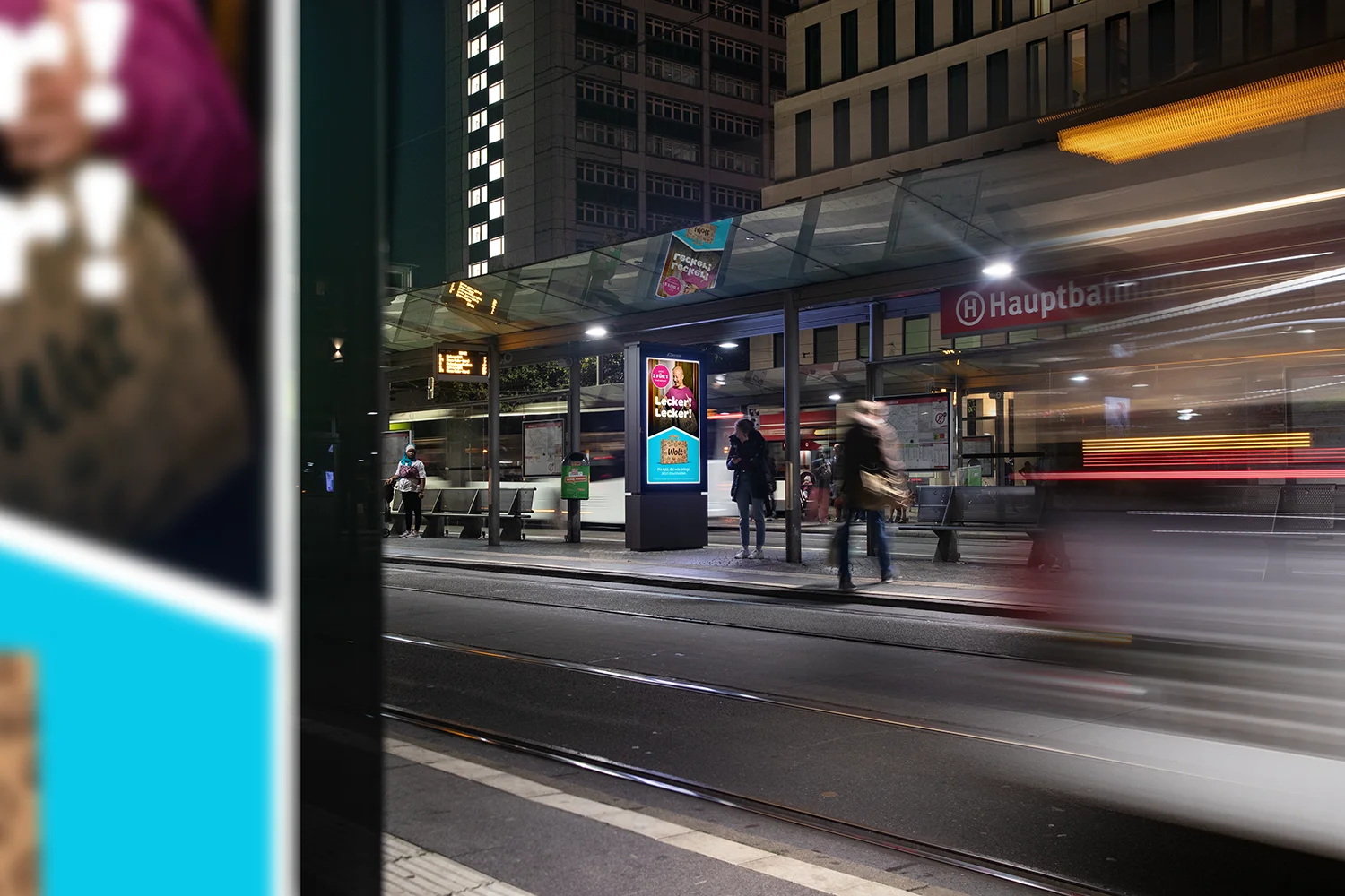Digital City Light Poster mit Werbung für einen Lieferdienst am Bremer Hauptbahnhof bei Nacht.