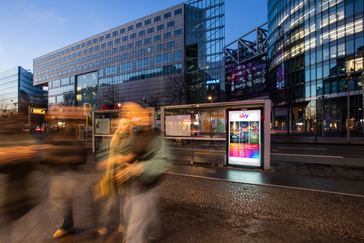 Digital City Light Poster in Buswartehalle zeigt Werbung für Streamingdienst am Potsdamer Platz in Berlin bei Nacht.