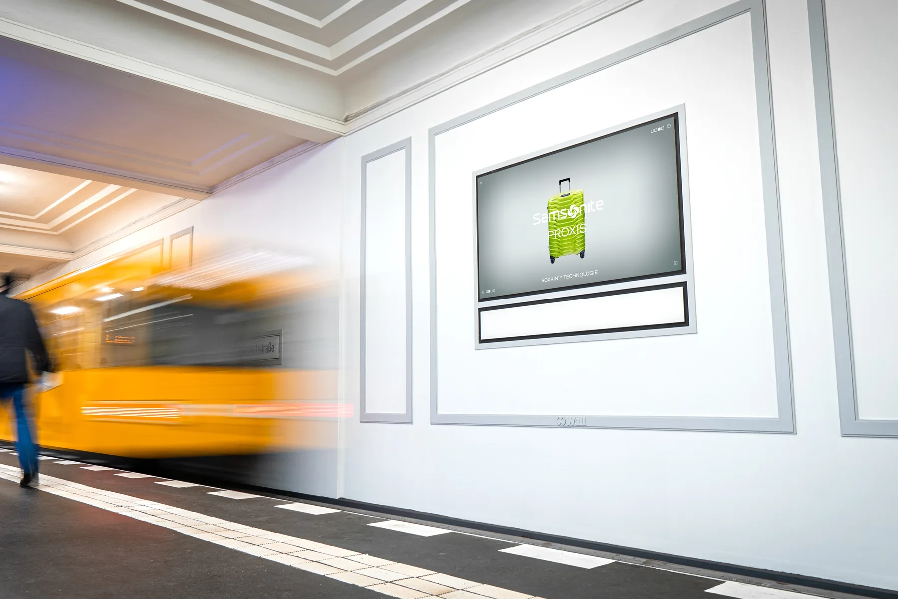 OOH-Werbung einer Koffer-Marke auf den Screens der Digital Postergallerie in der U-Bahnstation Friedrichstraße in Berlin.