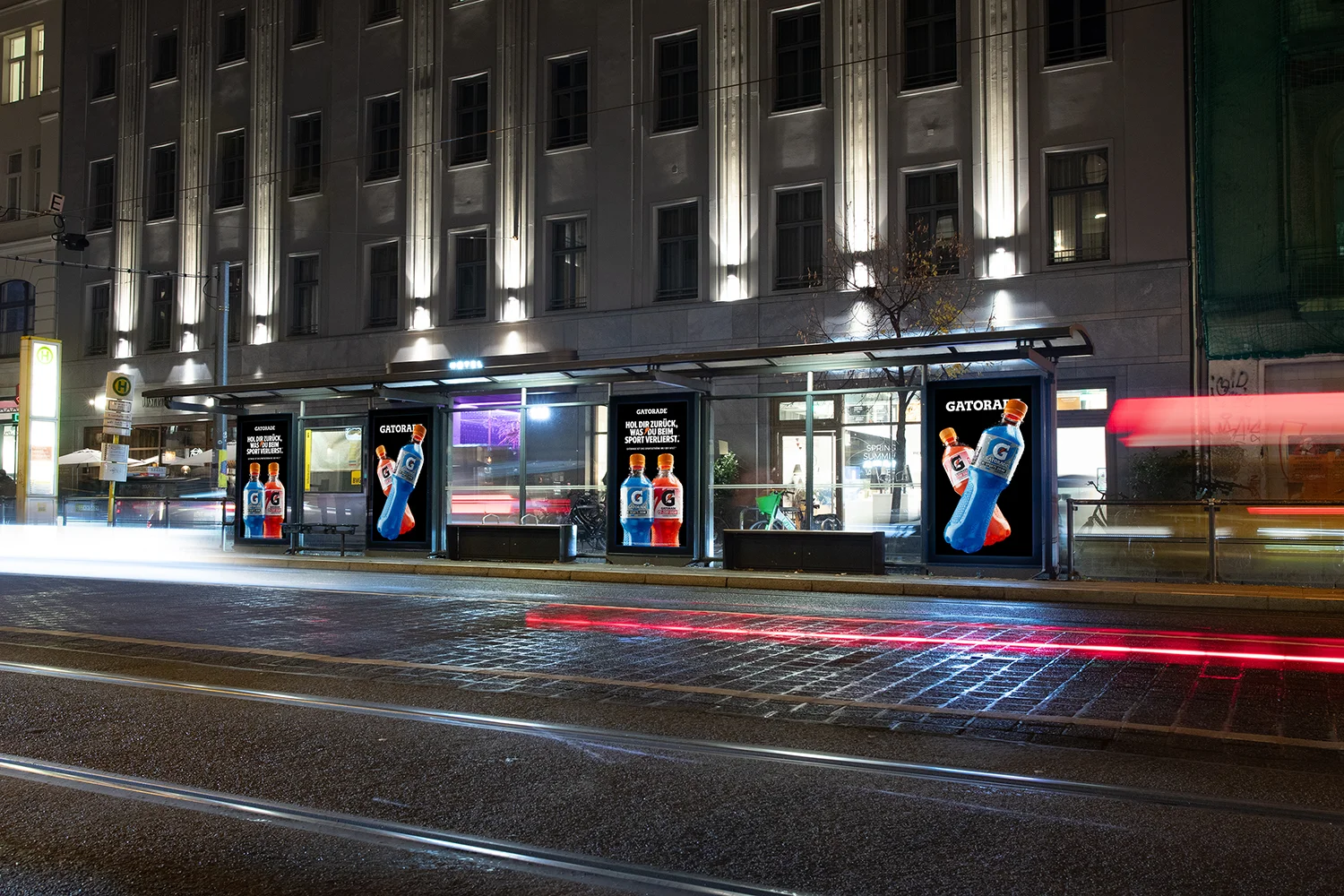 Drei Digital City Light Poster mit Werbung für Engery Drinks an einer Tramhaltestelle in der Friedrichstraße in Berlin.
