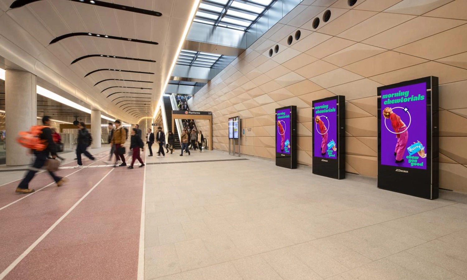 Drei Digital City Light Poster mit Kaugummiwerbung im inneren der Brisbane Central Station.