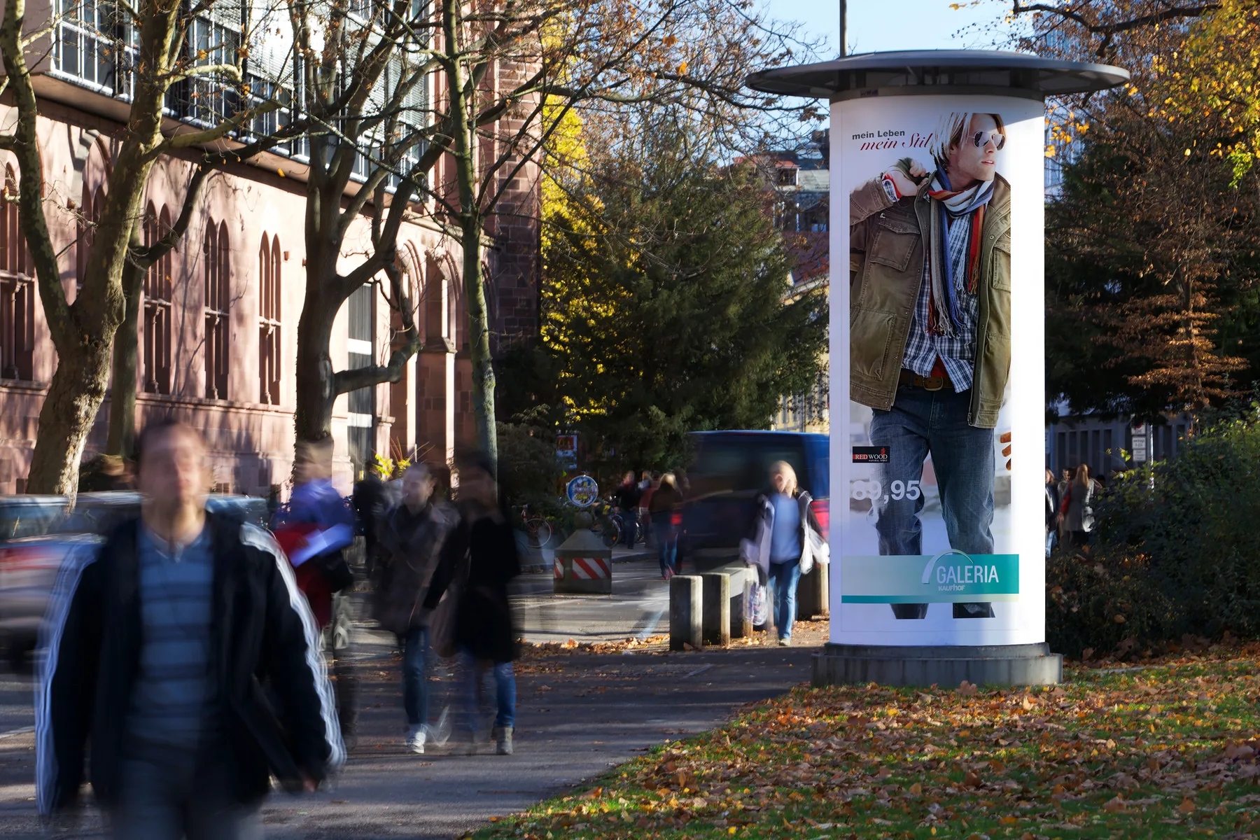 Ganzstelle mit OOH-Werbung eines Warenhauses in der Innenstadt von Freiburg.