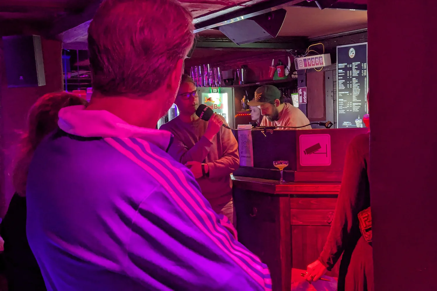 Person mit Mikrofon stehend vor einer Gruppe Menschen hält Vortrag.