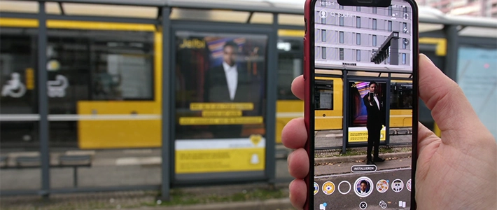 Bild vom virtuellen Filter-Erlebnis auf einem Smartphone von einer social media app an einer Berliner Tram-Wartehalle.