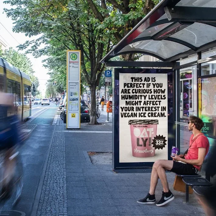 Digital City Light Poster in Bus-Wartehalle zeigt Werbung für veganes Eis.