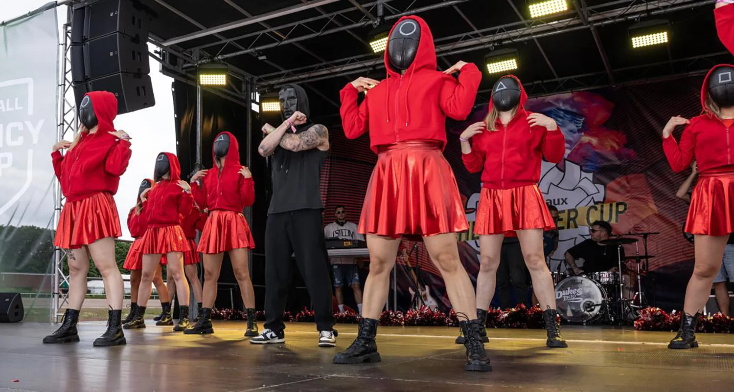 Die Cheerleader:innen der Pilot tanzen auf der Bühne in Squid-Game Kostümen auf der WallDecaux Cheerleader Cup 2025.