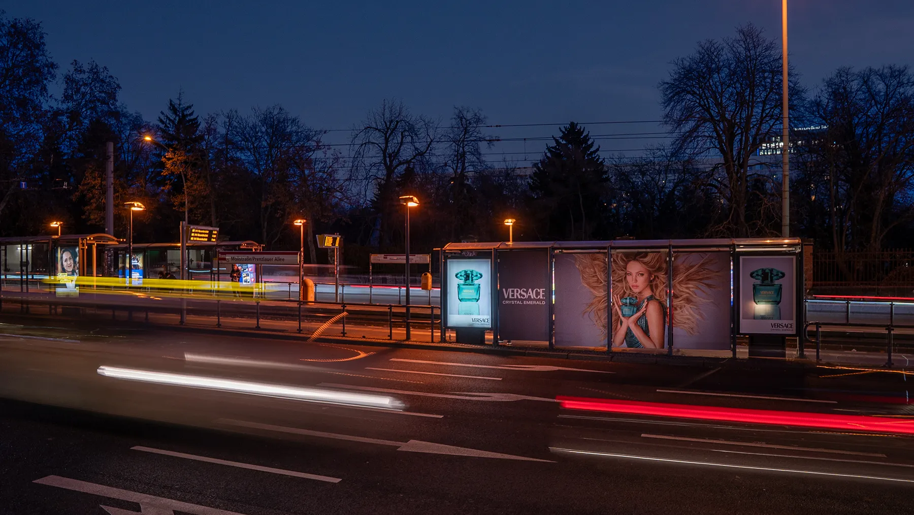 Wartehallenbranding an einer Tramhaltestelle in der Prenzlauer Alle in Berlin zeigt Parfum-Werbung.