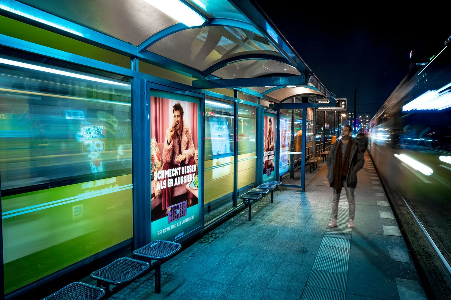 Zwei City Light Poster an Wartehalle an Tram-Wartehalle in Berlin bei Nacht.